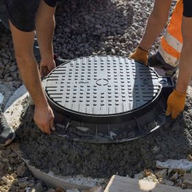 a-cast-iron-sewer-hatch-is-being-installed-in-a-concrete-well-in-preparation-for-the-installation.jpg